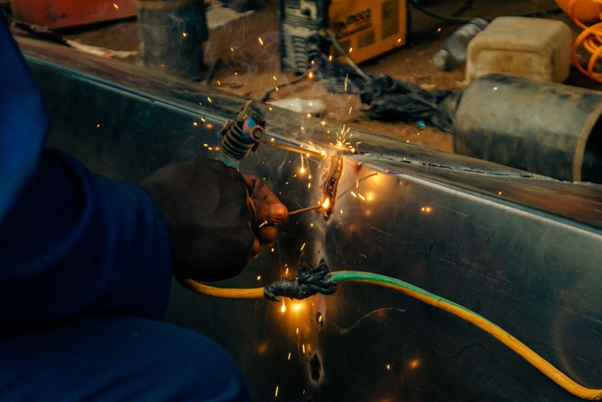 作業場で金属を溶接する溶接工